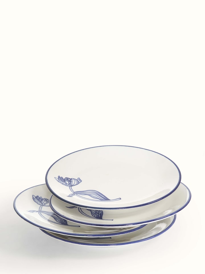 Detailed view of white and blue Khurja pottery ceramic dinner plates, showcasing intricate designs and craftsmanship.