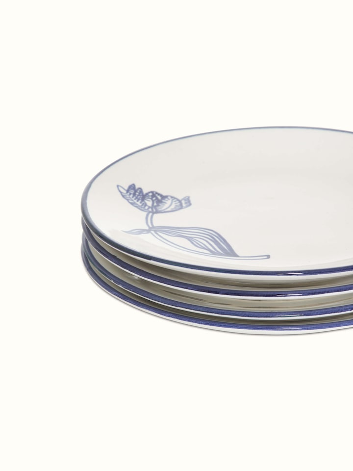 Close-up of the edge of white and blue Khurja pottery ceramic dinner plates, highlighting the detailed rim design.