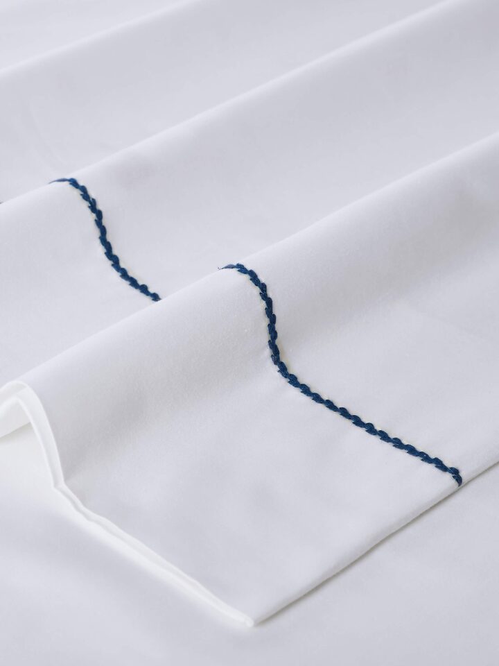 Angled view of Shivranjini blue stripe cotton hand embroidered bedsheet king set (3 pcs), emphasizing the design and color.