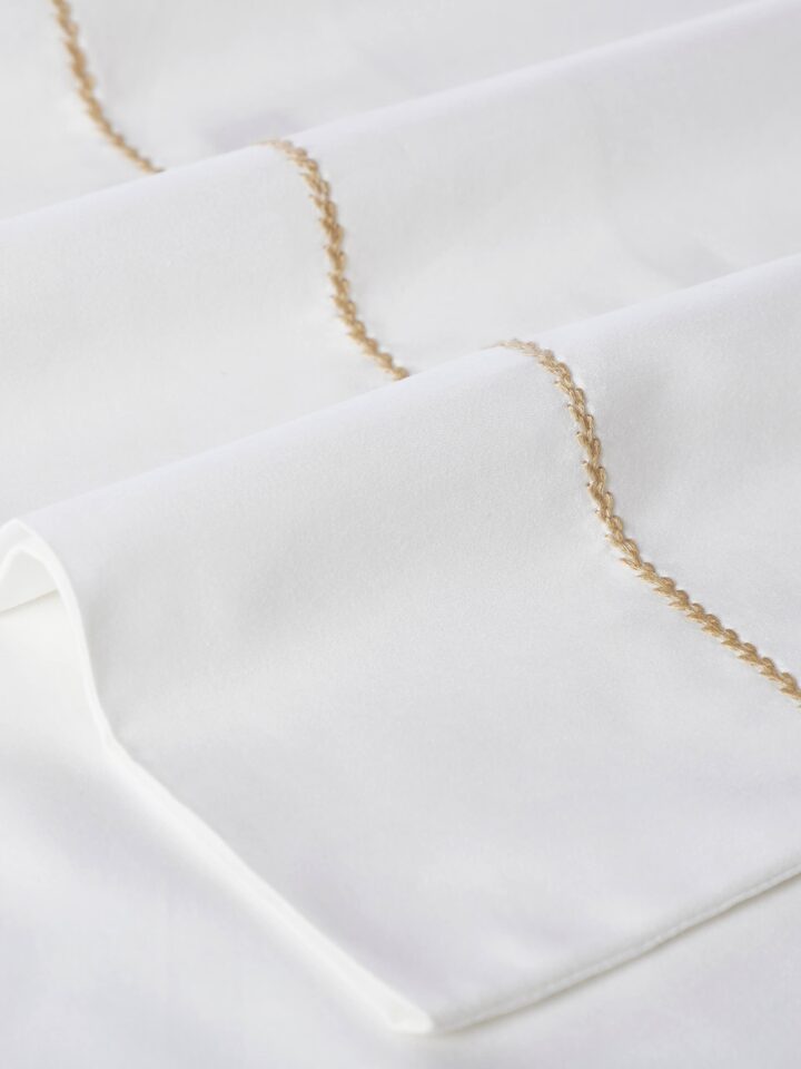 Shivranjini beige stripe cotton hand embroidered bedsheet king set displayed on a bed, showcasing its design and use in a bedroom setting.
