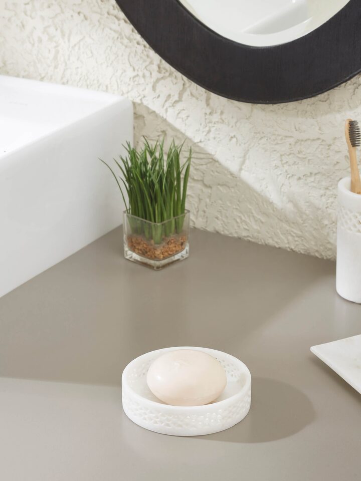 Close-up of carved Ambaji white marble soap dish, showcasing detailed carving and smooth surface.