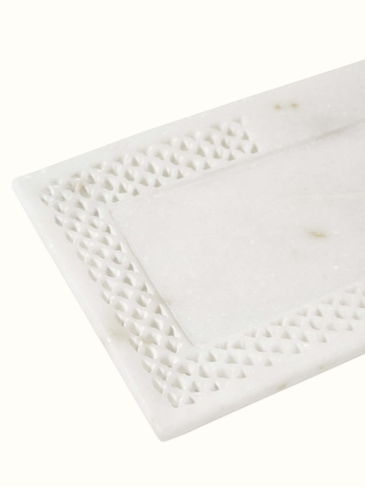 Close-up view of Carved Ambaji marble bath tray in white, highlighting intricate carvings and smooth texture.