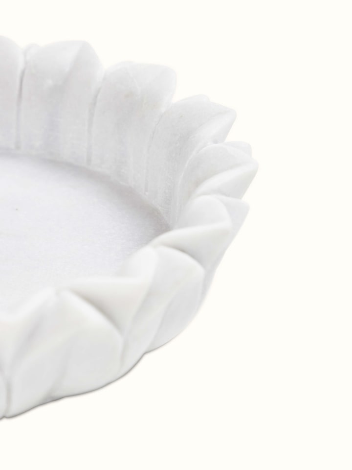 Close-up of Glossy Carved Marble Urli showcasing elegant design details.