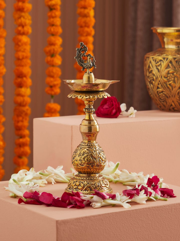 Side view of polished brass Stambh Vilakku highlighting its detailed craftsmanship and polished finish
