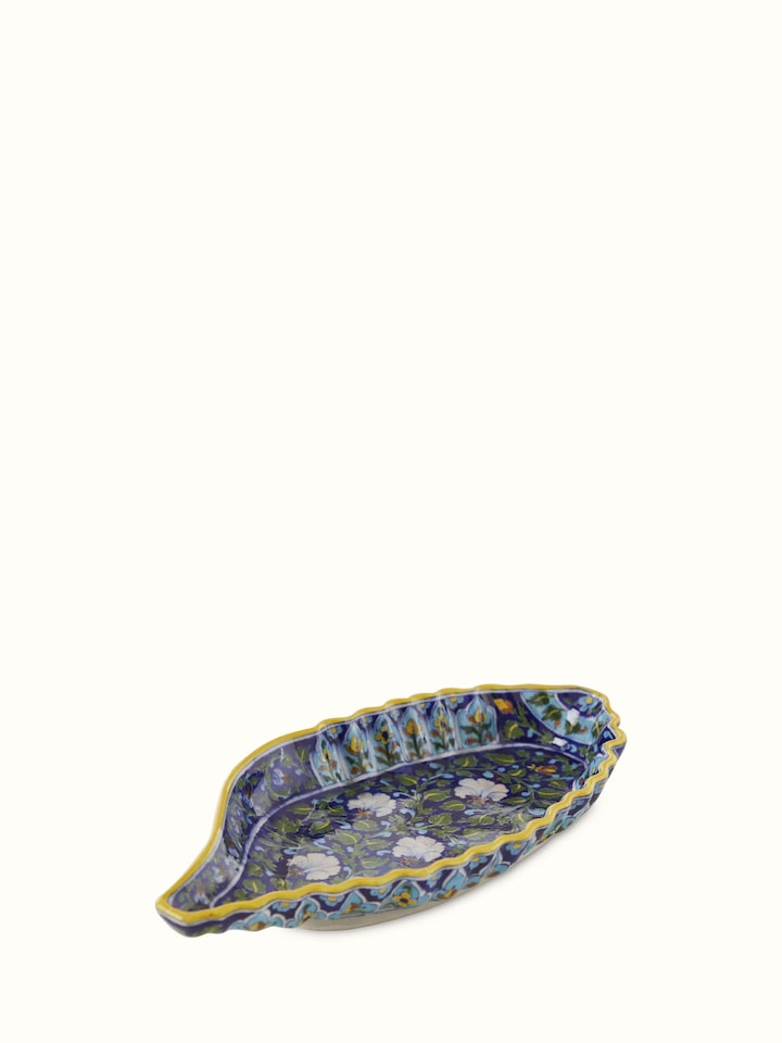 Angled view of blue pottery ceramic conch shell planter, displaying its artistic shape and vibrant glaze.