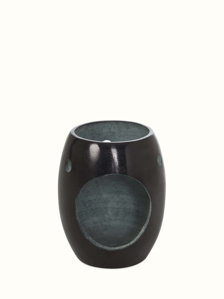 Side view of the carved stone diffuser, showcasing the texture and craftsmanship of the design.