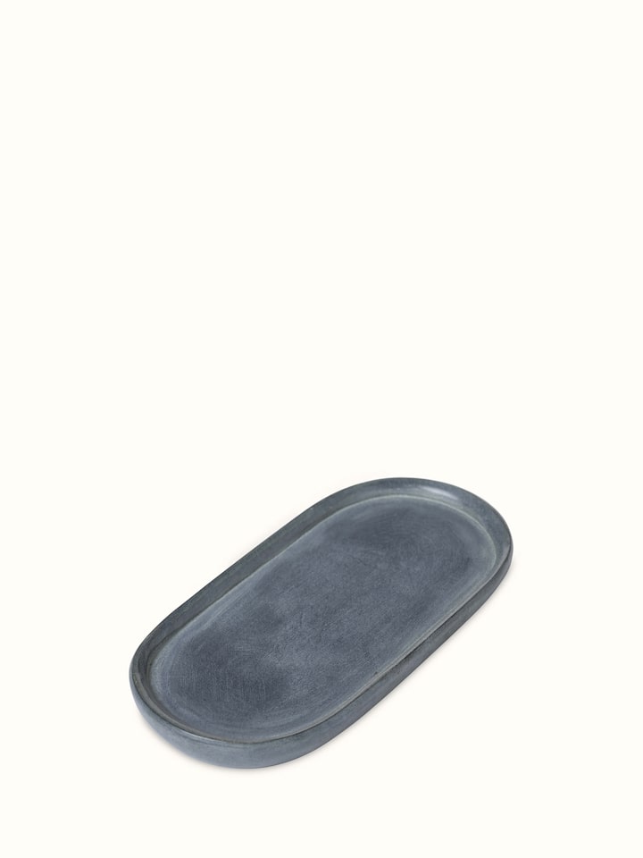 Angled view of natural carved stone bath tray, highlighting the detailed carvings and stone texture.