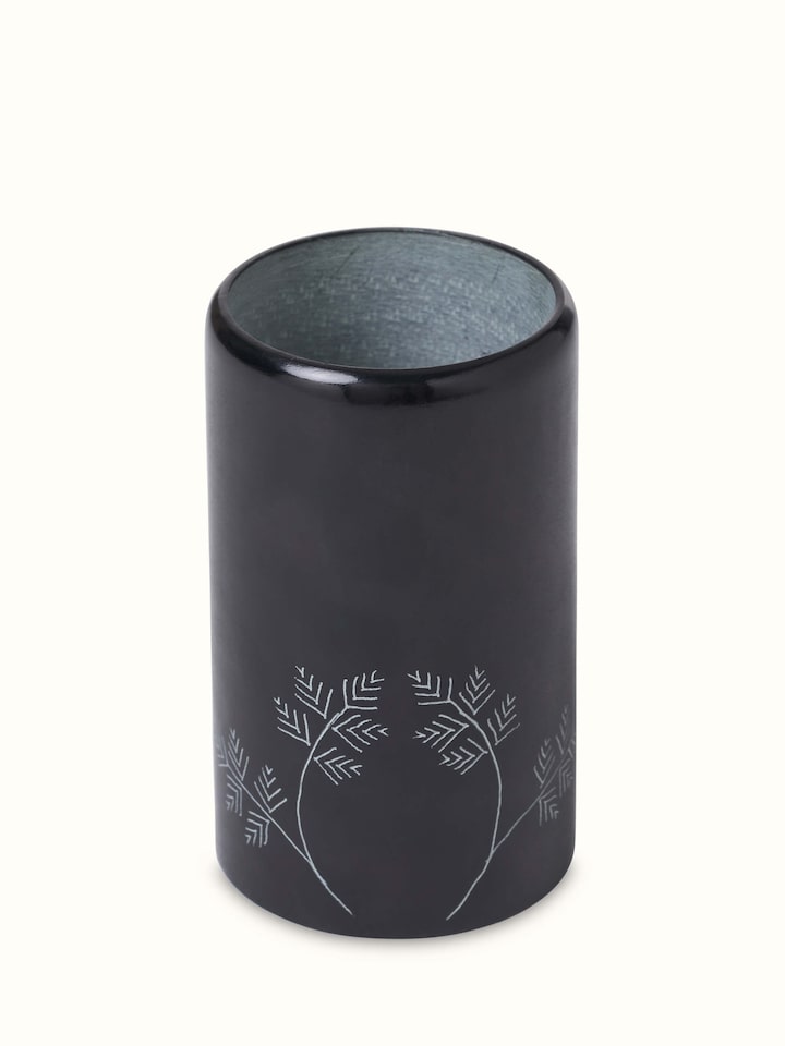 Angled view of glossy carved stone toothbrush holder highlighting its artistic carving and finish