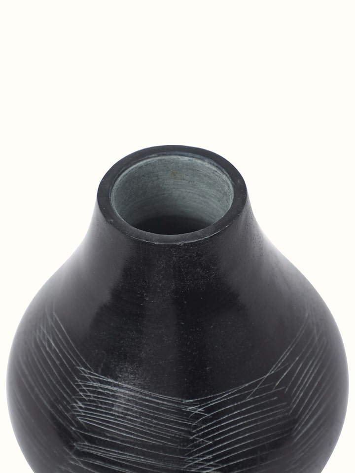 Close-up of carved stone vase in black color showcasing intricate details and craftsmanship