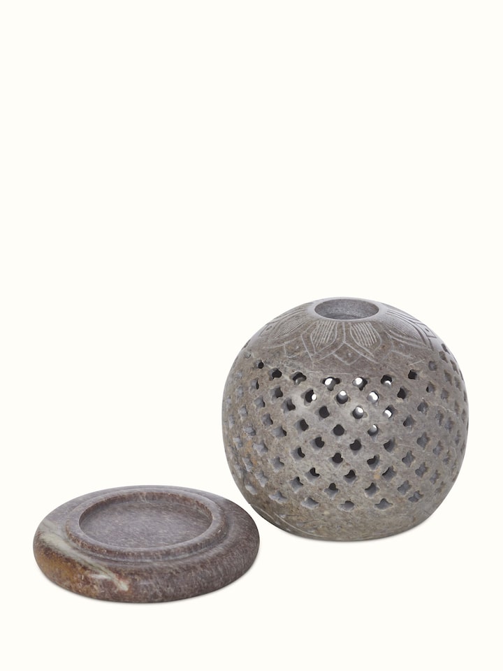 Natural carved stone tea light holder with a unique pattern and smooth texture, ideal for decorative lighting.