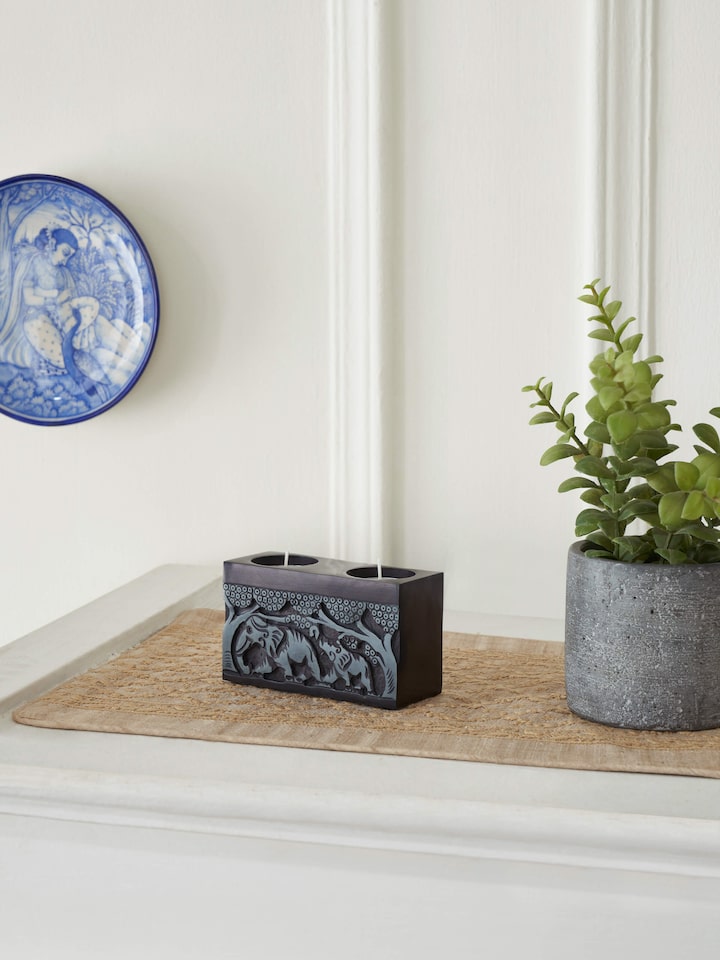 Side view of Transitional Carved Stone Tea Light Holder, showing the detailed stonework and functional design.
