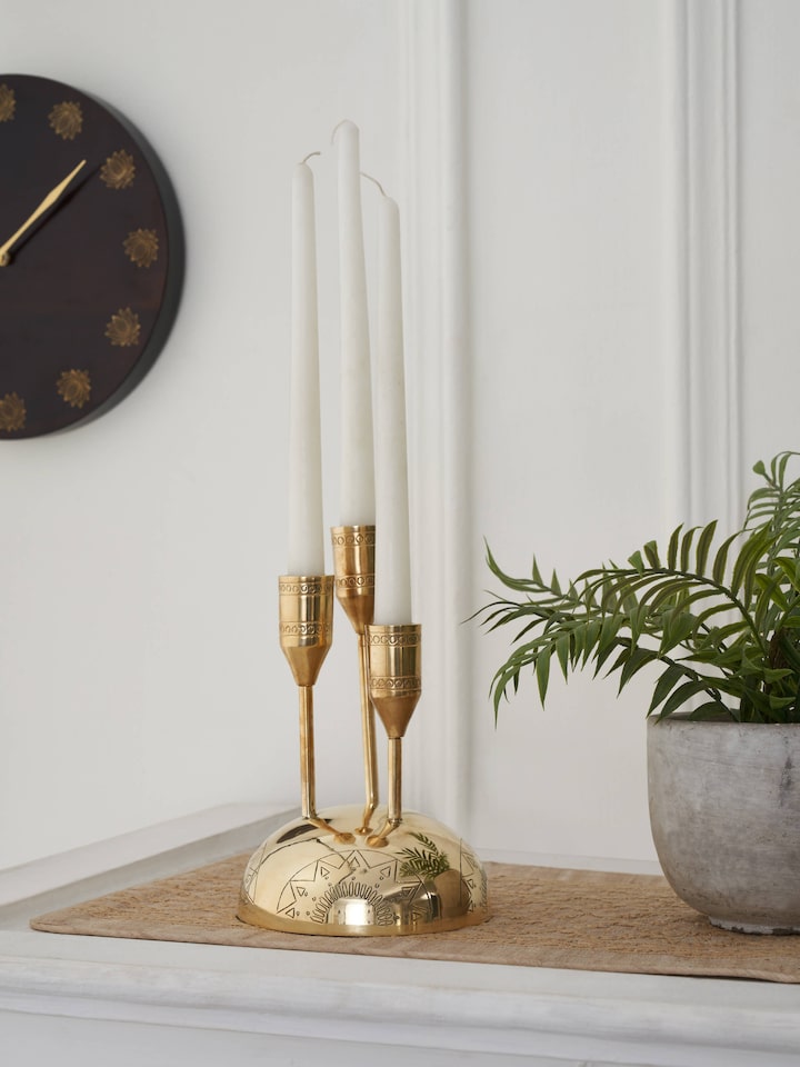 Side view of Brass candle holder in golden color highlighting intricate patterns and polished surface.