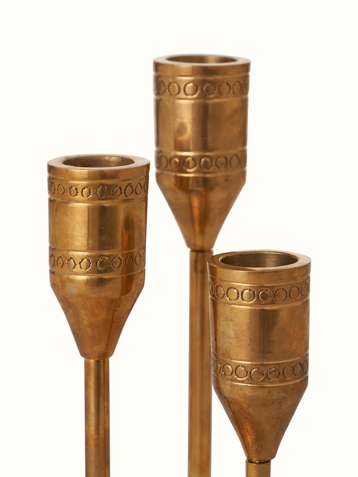 Close-up view of Brass candle holder in golden color focusing on detailed craftsmanship and reflective quality.