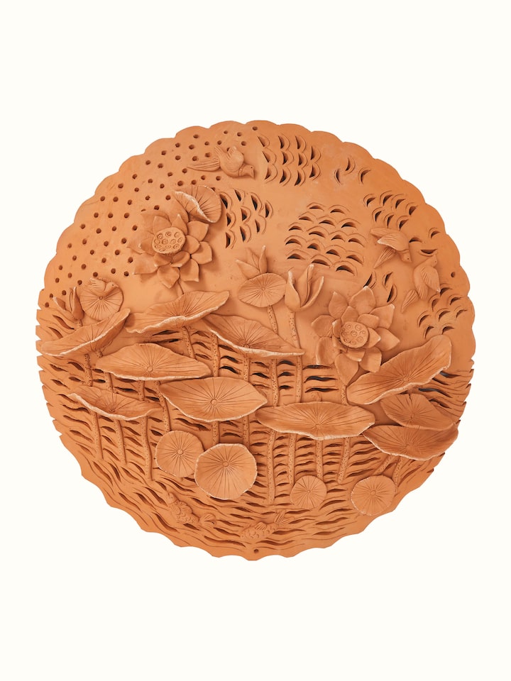Front view of terracotta clay lotus cutout sculpture plate showcasing intricate design