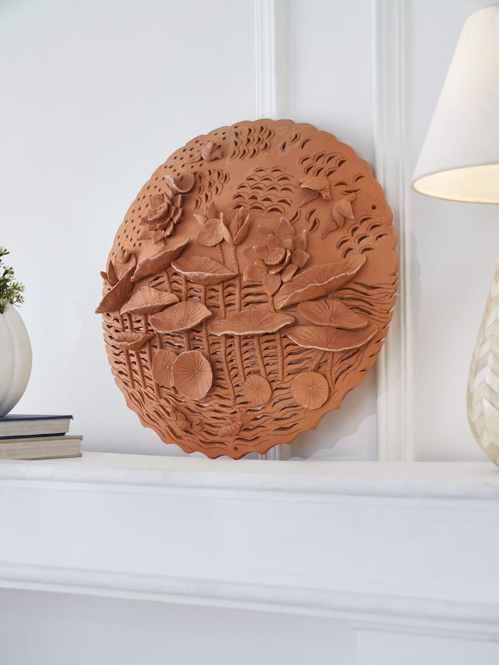 Top view of terracotta clay lotus cutout sculpture plate emphasizing artistic craftsmanship