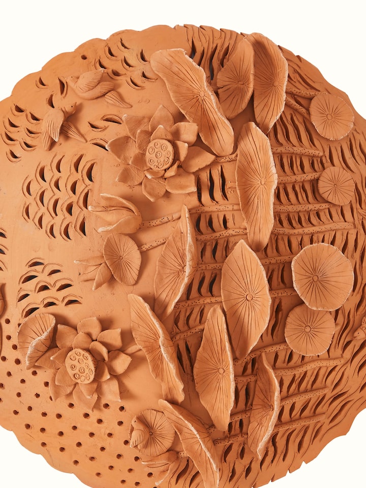 Detailed view of terracotta clay lotus cutout sculpture plate with elegant design