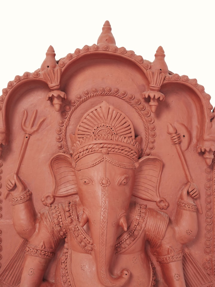 Close-up of terracotta clay Ganesha idol, highlighting its detailed craftsmanship and vibrant colors.