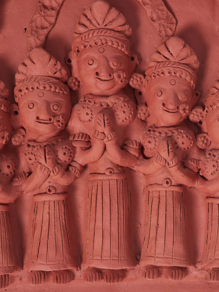 Side view of terracotta clay five lords sculpture, showing its detailed carvings and design.