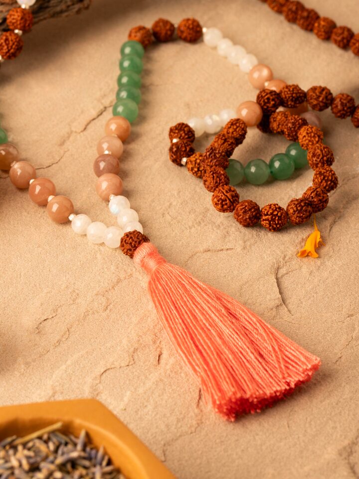 Side view of Peach & White Moonstone, Green Aventurine & Rudraksha Silver Mala displaying the depth and bead size of the mala.
