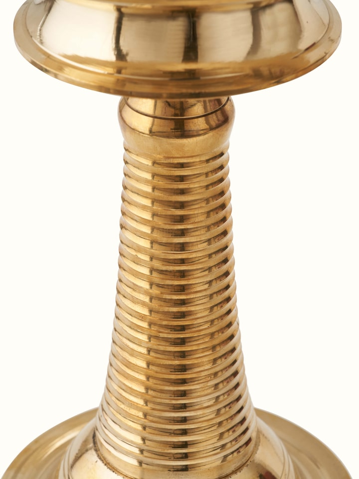Side view of brass kuthu vilakku stand diya, emphasizing its elegant curves and traditional craftsmanship.