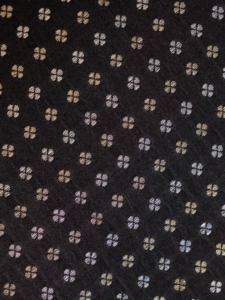 Close-up of Adil Banarasi Table Mat, highlighting rich black silk base with gold brocade accents.