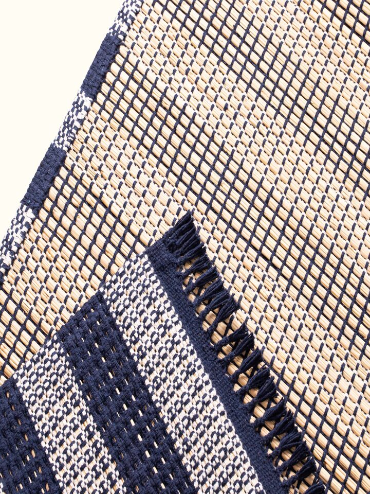 Side view of Indigo Stripe Natural Grass Cotton Yoga Mat highlighting the stripes and textured surface