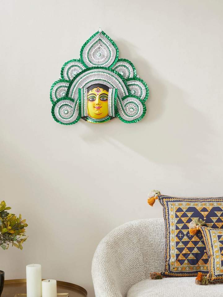 Side view of green chhau clay and paper goddess Durga wall mask focusing on intricate details.