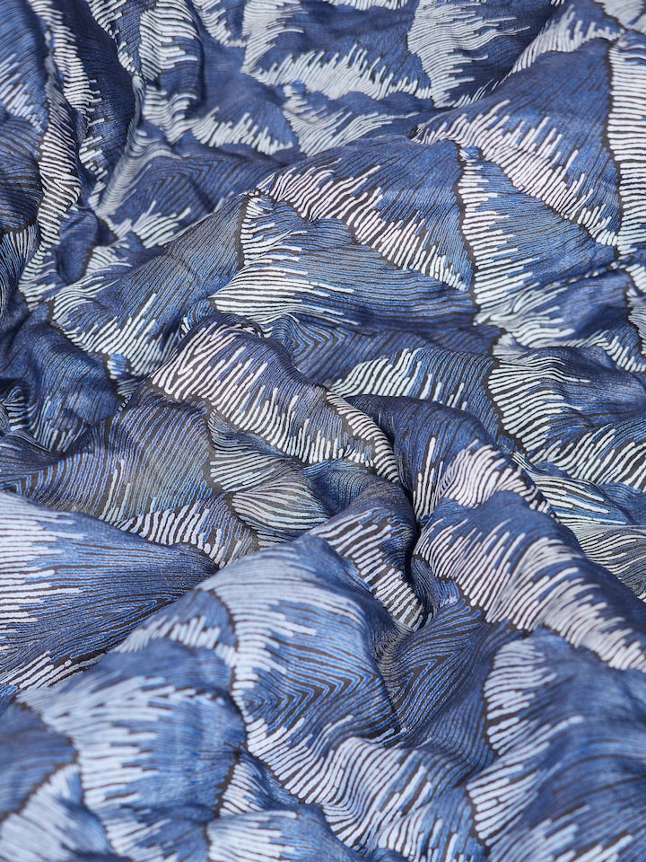 Parvat indigo ombre quilt folded, displaying its design and texture