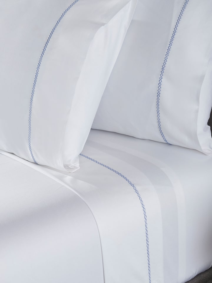 Detailed view of the hand embroidery on the Parvat blue stripe cotton king bedsheet set