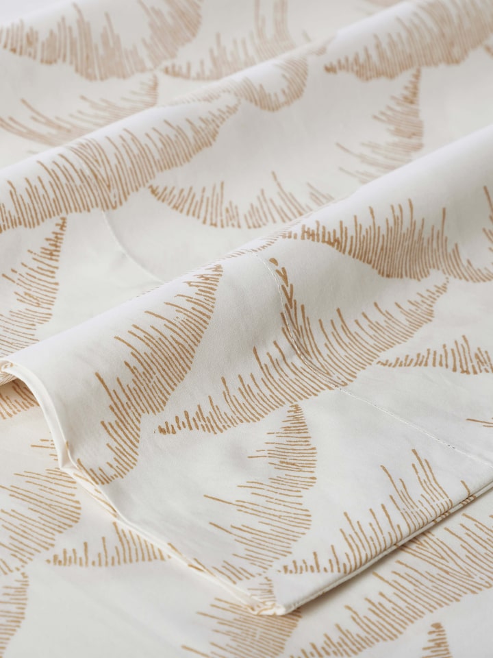 Parvat beige textured cotton Sanganeri block printed queen bedsheet set (3 pcs) arranged to show its use and design in a bedroom setting.