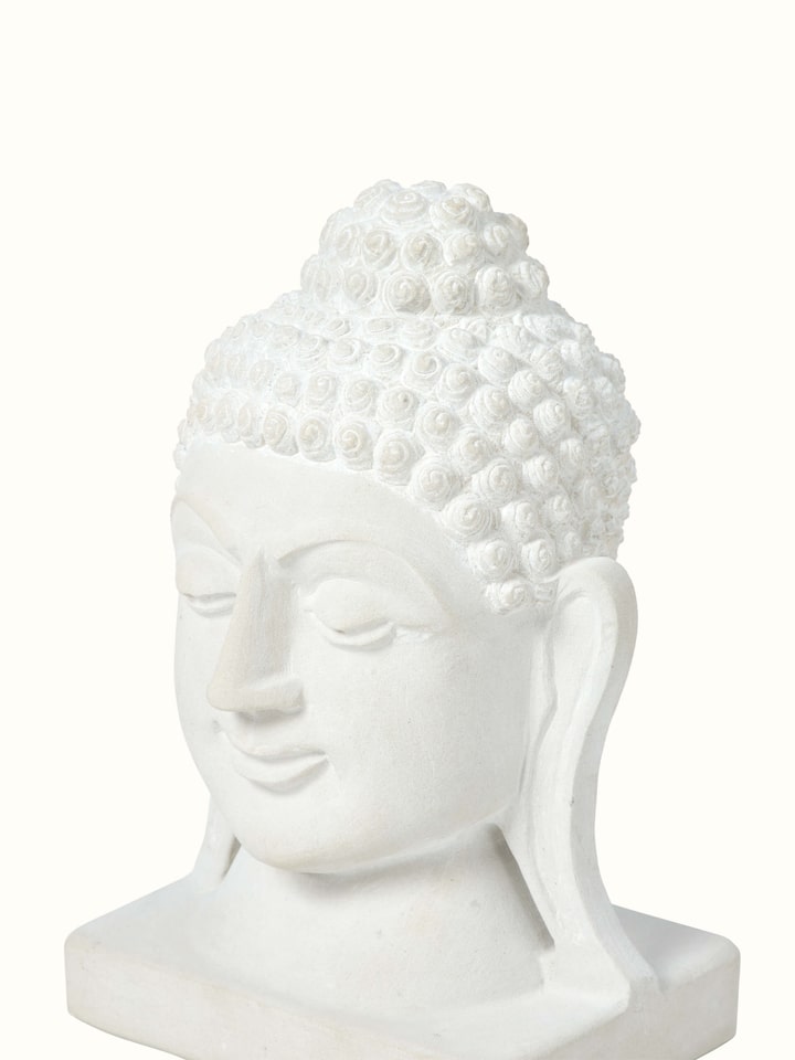 Angle view of Tranquil Carved Stone Buddha Face Idol displaying the serene expression