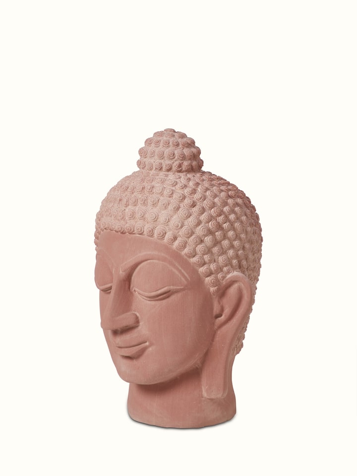 Angled view of serene carved stone Buddha face idol, highlighting the intricate stonework and tranquil features