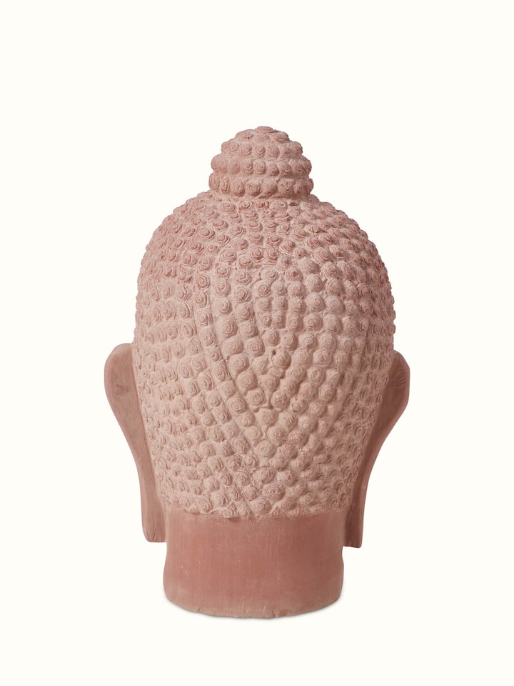 Side view of serene carved stone Buddha face idol, showcasing the depth and texture of the stone carving