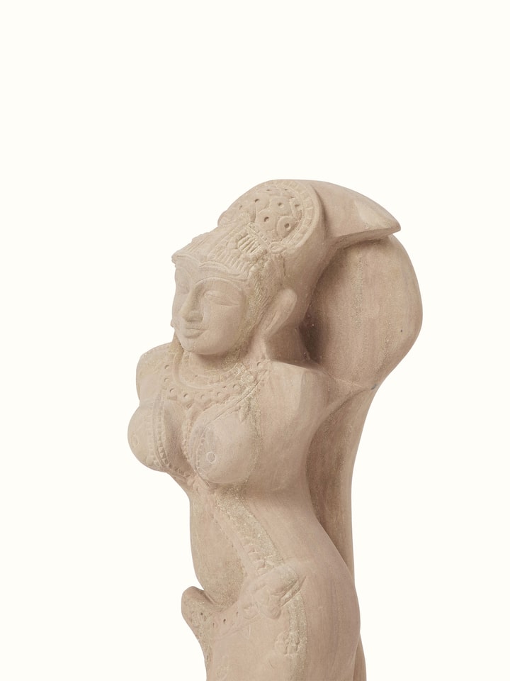 Angled view of Graceful carved stone shilabalika sculpture emphasizing the craftsmanship and stone texture