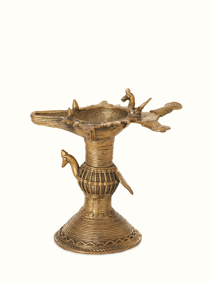 Detailed close-up of antique brass dhokra diya, focusing on the intricate patterns and high-quality brass material