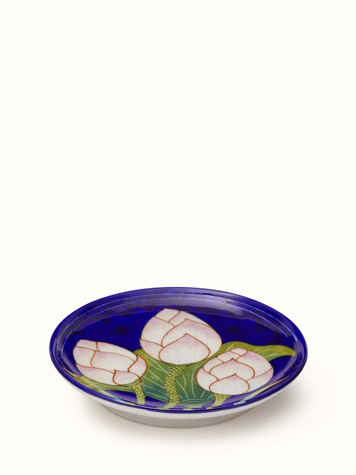 Close-up view of Blue Pottery Three Flowers Display Plate from Swadesh, focusing on the floral design and vibrant ceramic colors.