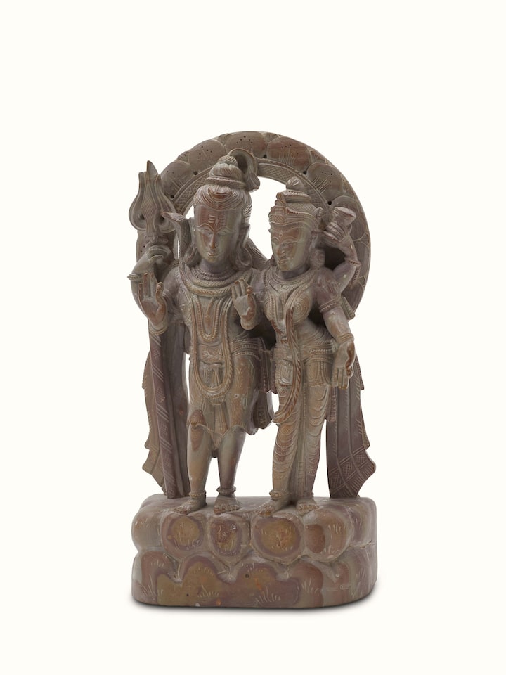 Close-up of carved stone Shiva & Parvati idol, highlighting the detailed carving and artistry.