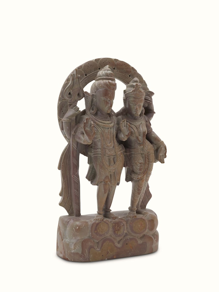 Side view of carved stone Shiva & Parvati idol, focusing on the craftsmanship and fine details.