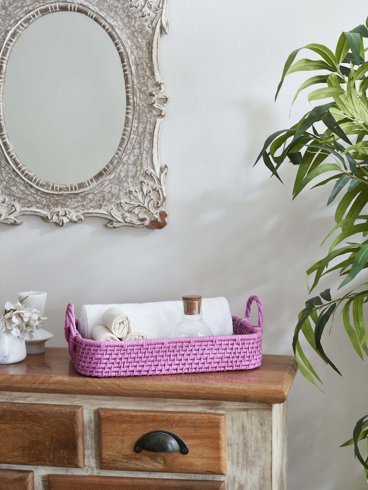 Side view of cane storage organiser in pink color, highlighting the woven cane texture and stylish pink finish