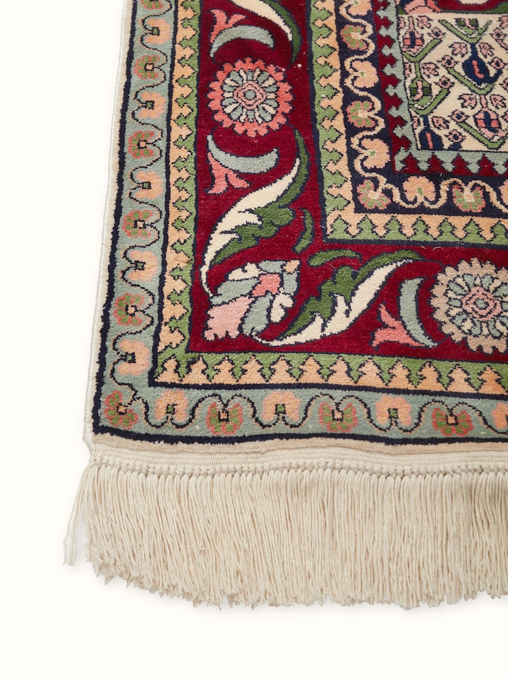 Angled view of Traditional Persian Isfahan Kashmir silk hand-knotted carpet highlighting vibrant color palette