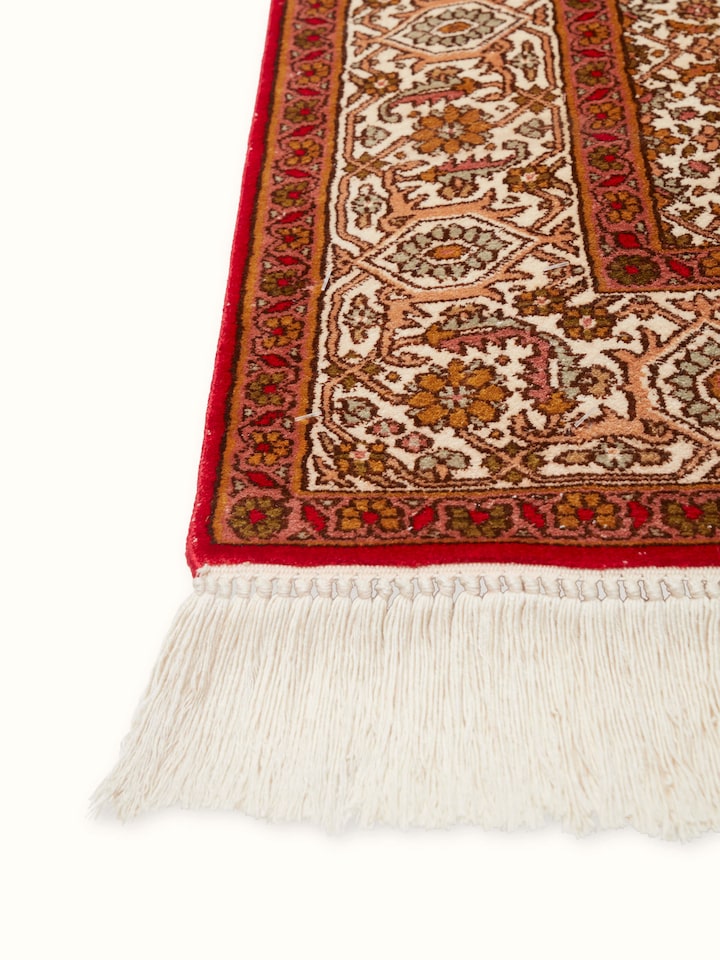 Close-up of Traditional Persian Red Senneh Kashmir Silk Hand-Knotted Carpet highlighting the detailed craftsmanship and patterns.