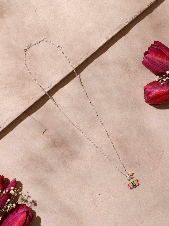 Angled side view highlighting the meenakari design and silver chain attached to the pendant