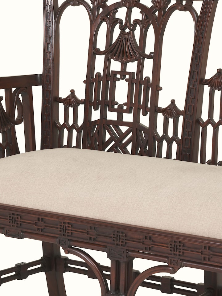 Detail shot of upholstered mahogany wood sofa showing close-up of seat cushions and wood grain