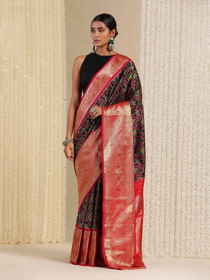 Model styled in blue Ikat silk saree in a modern setting, mid-length pose.