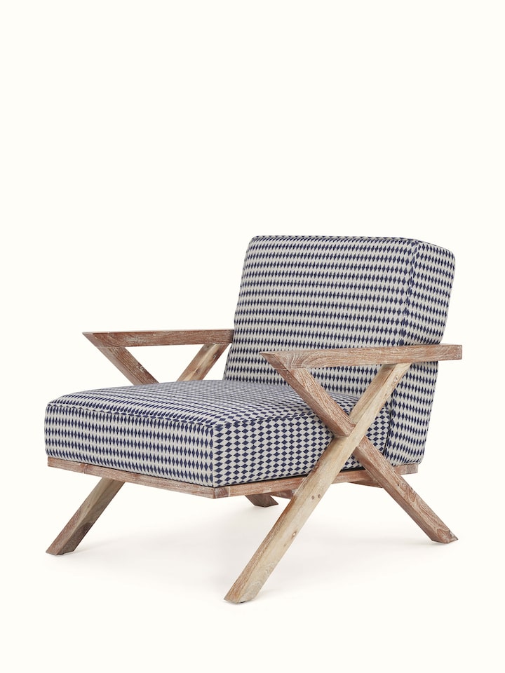 Angled view of Swadesh Upholstered Acacia Wood Armchair showing its cozy, padded seat and finely crafted wood structure