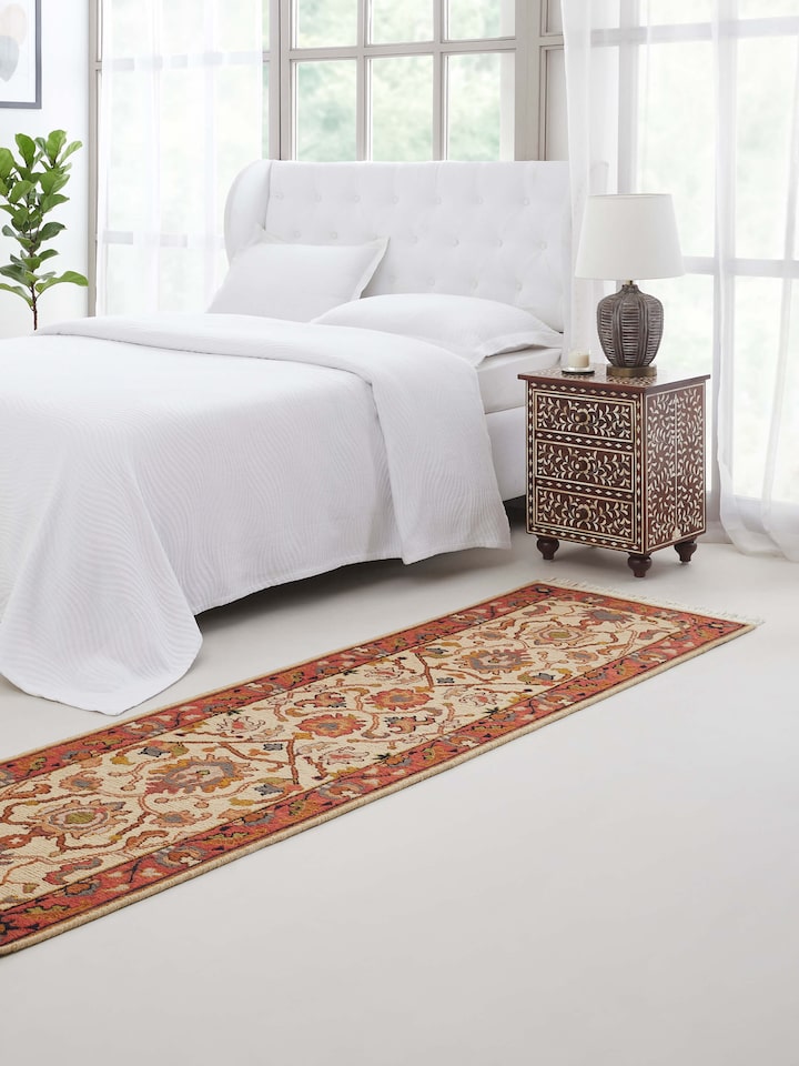 Long off-white Persian Sumak Bhadohi wool runner with intricate motifs styled in a hallway.