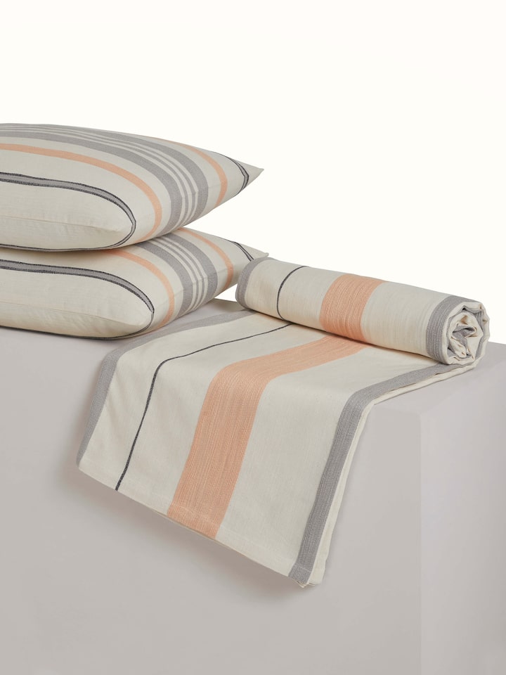 Backside view of the handloom cotton bedspread, showing neat tailoring and stripe design.