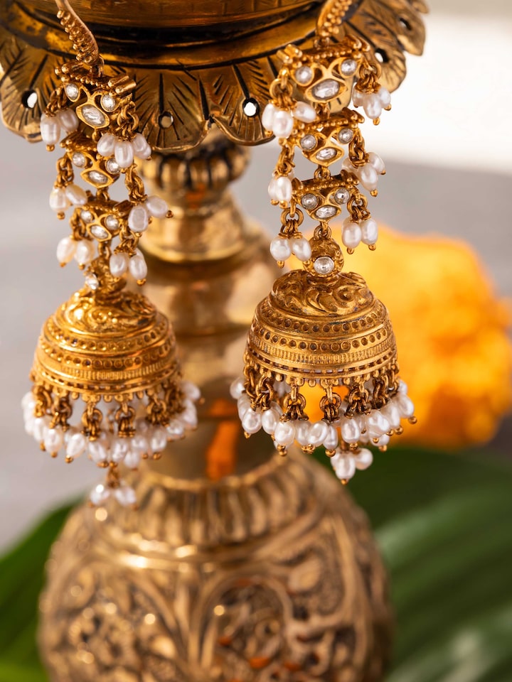 Close-up of silver Guttapusalu jhumkas in ear, highlighting pearls and filigree detailing.