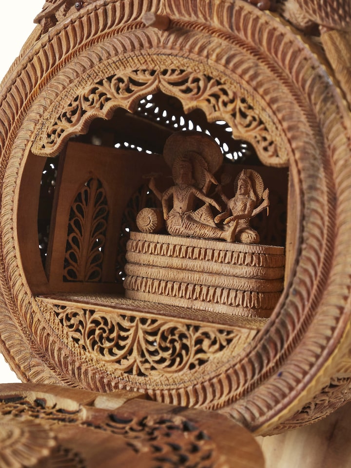 Detailed side view of carved sandalwood veena sculpture, showcasing the artistic carvings and smooth finish.