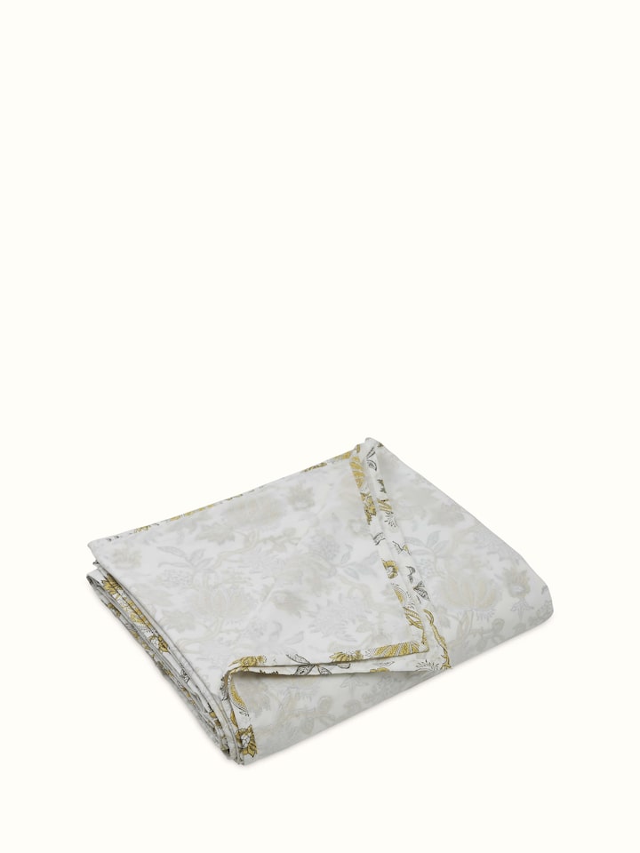 Angled close-up of floral block print on yellow cotton dohar.